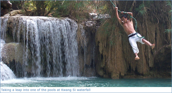 Taking a leap into one of the pools at Kwang Si Waterfall