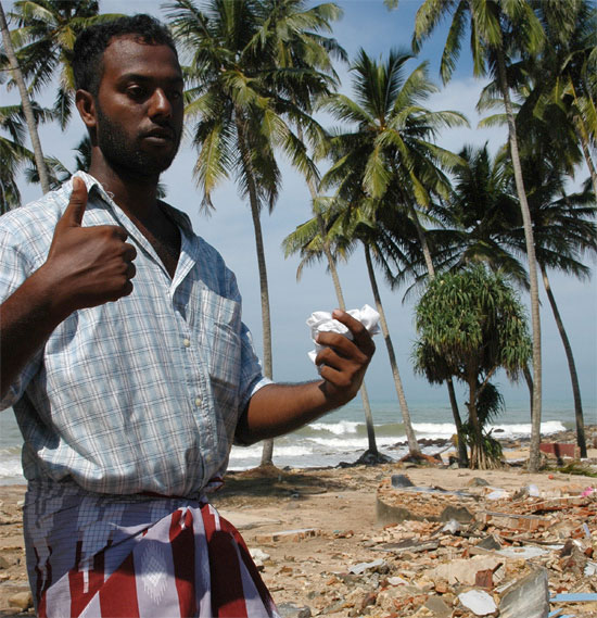 Man stands in front of where his house once stood